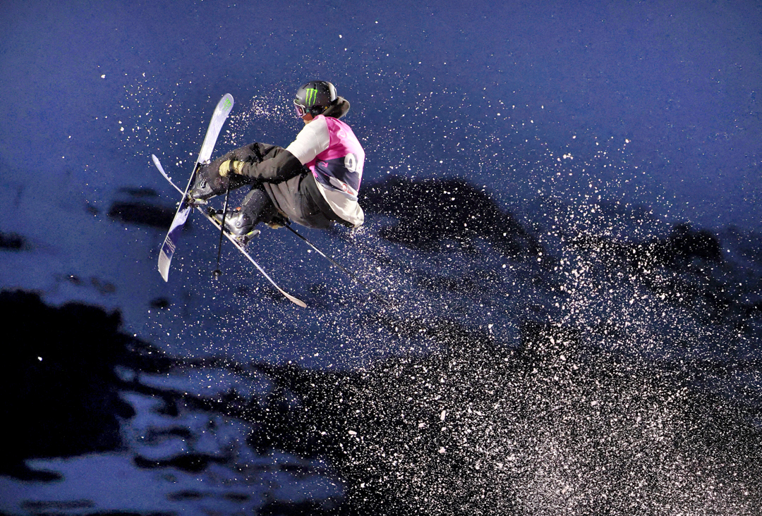 Freestyle skier mid-jump, cut out against the sky.