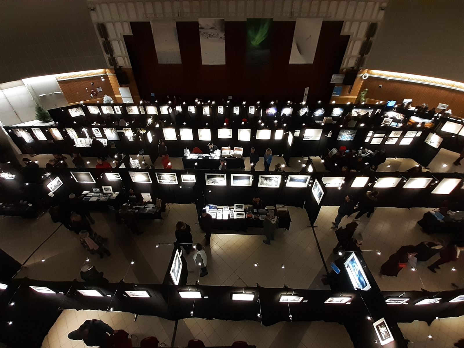 Overhead view of the Images & Neige exhibition hall, lined with lit photographs.
