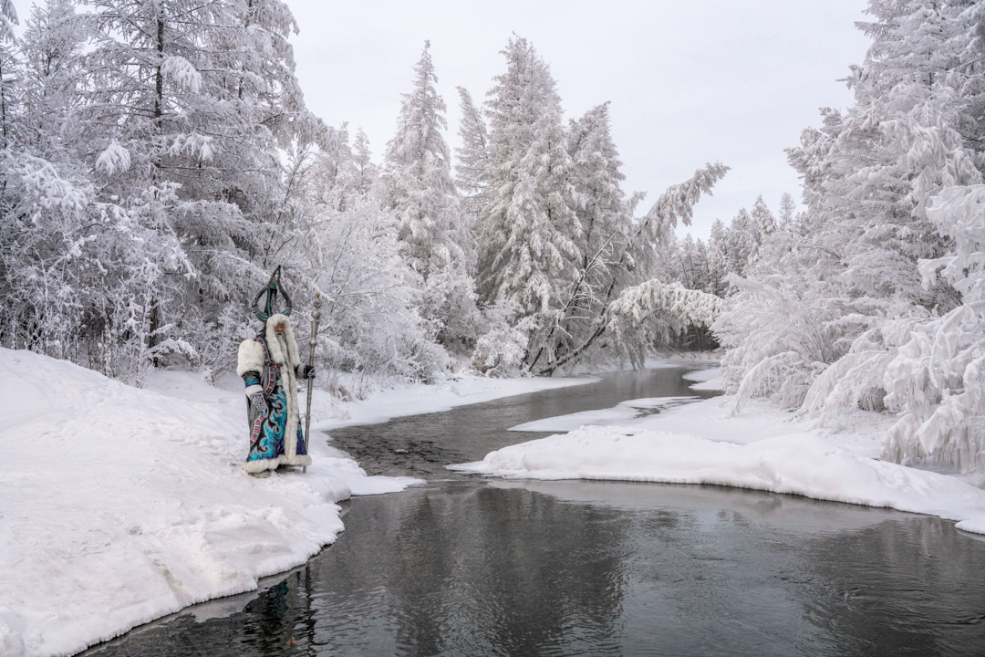 Snowy forest crossed by a river.